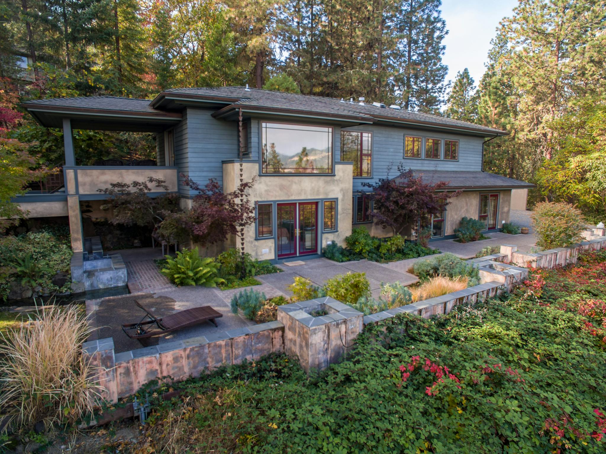 Contemporary two-story house surrounded by a lush garden, showcasing a stunning facade.